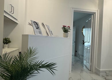 Elegant reception area at JM Cosmetics & Skin Clinic, Penarth, Wales, GB showcasing modern decor and plants.