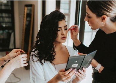 Makeup artist at Studio Luxe Collective, Bloemfontein, Free State, ZA, applying makeup to woman.