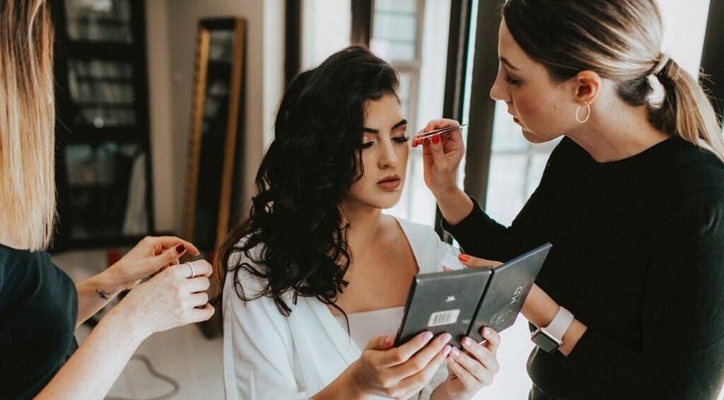 Makeup artist at Studio Luxe Collective, Bloemfontein, Free State, ZA, applying makeup to woman.
