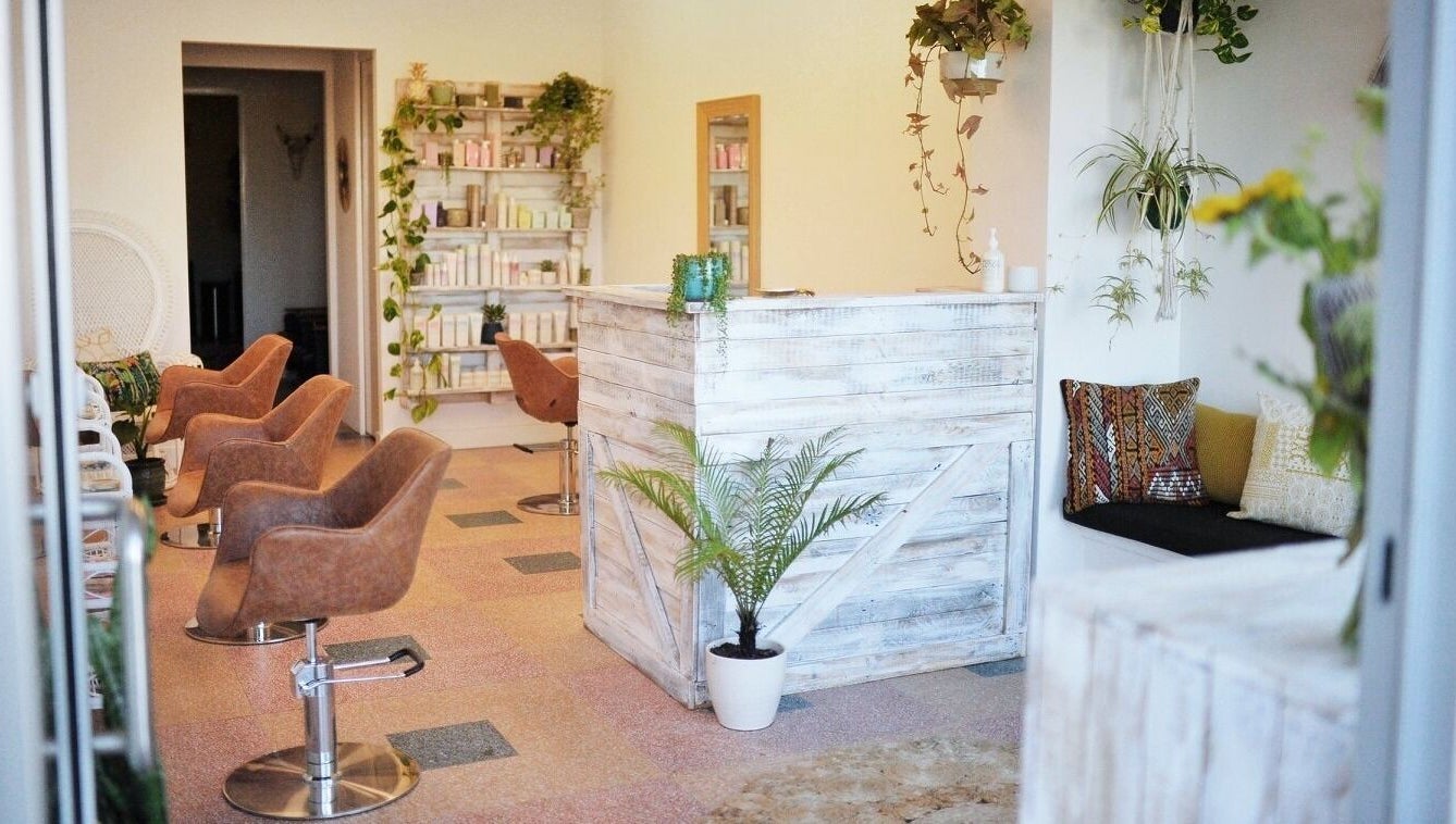 Boho Bombshell salon in White Gum Valley features rustic decor with chic styling chairs and lush greenery.
