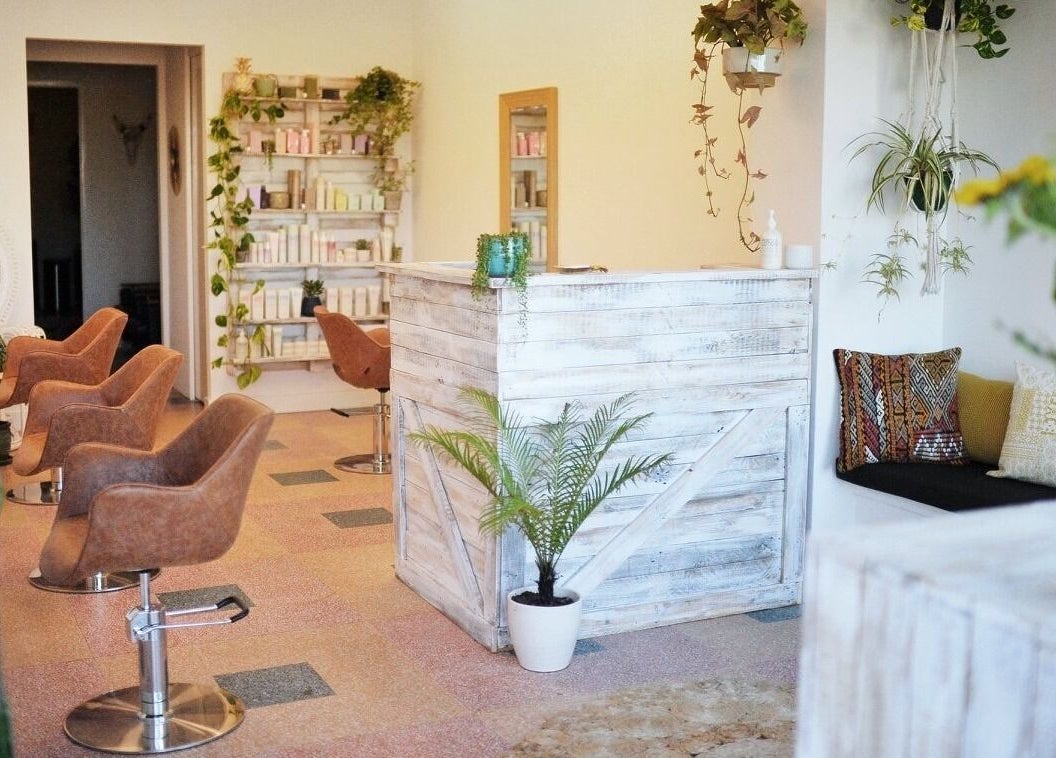 Boho Bombshell salon in White Gum Valley features rustic decor with chic styling chairs and lush greenery.