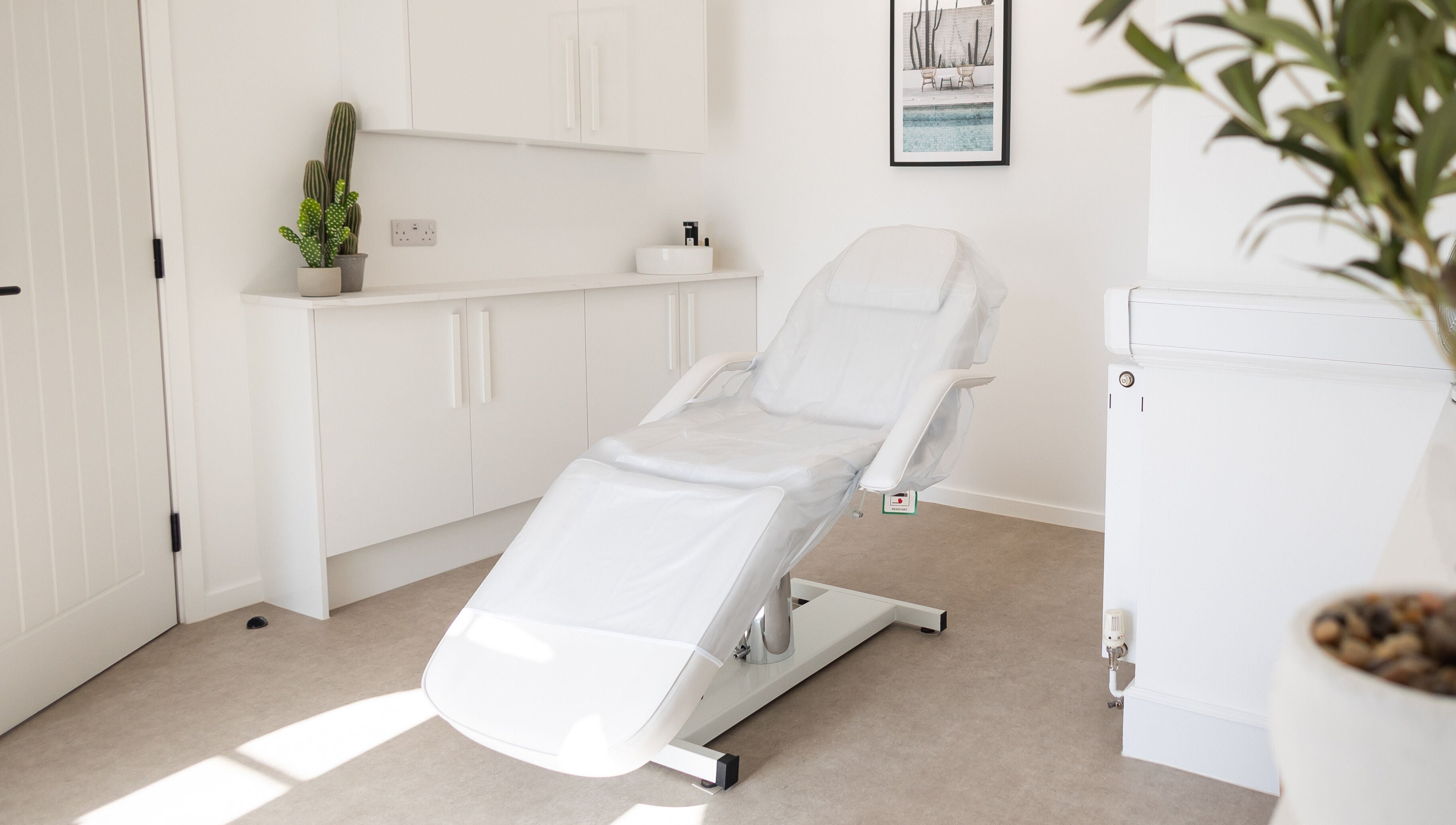 Calm, modern treatment room at Be. Laser and Skin Clinic, Taunton, England, GB, with a spa chair and plants.