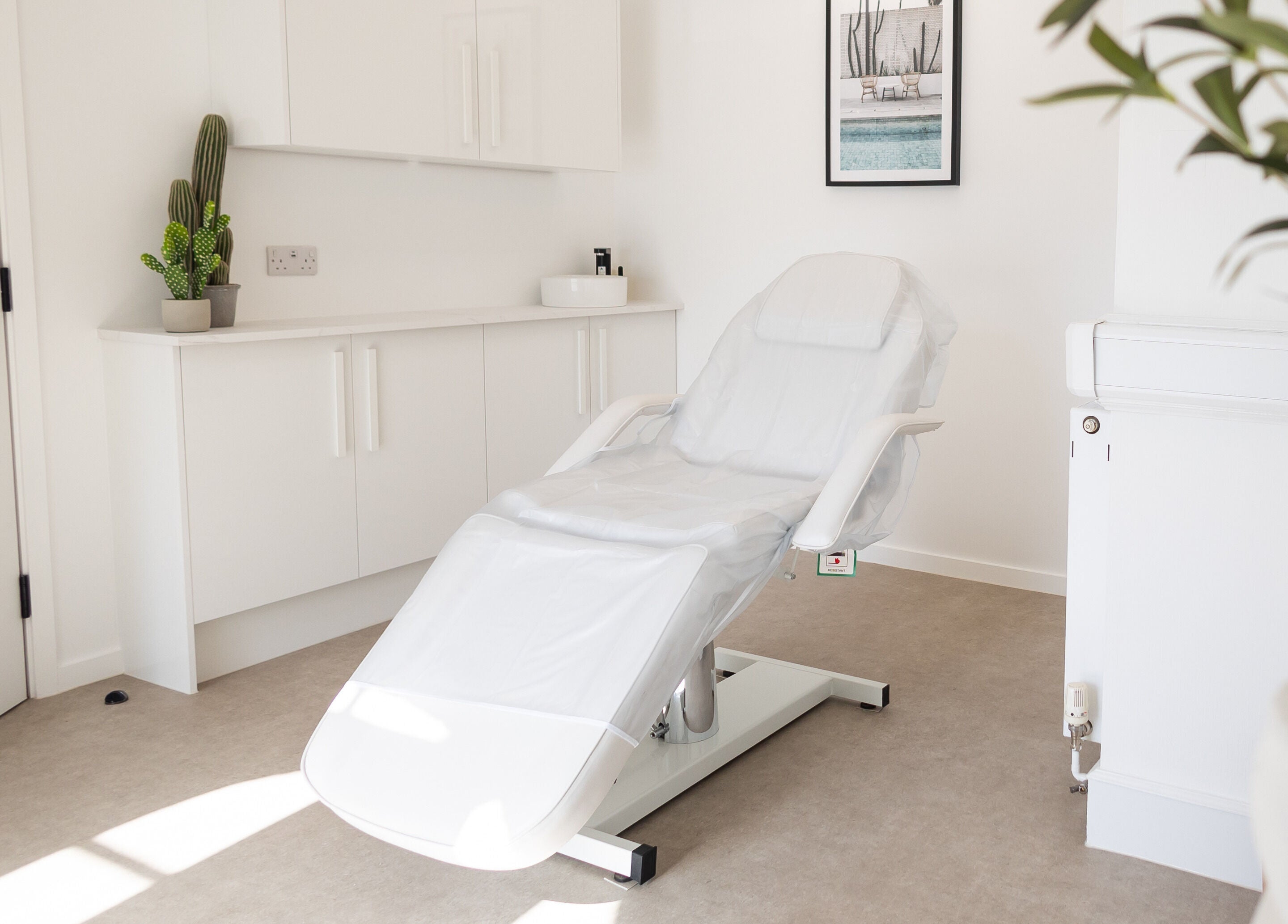 Calm, modern treatment room at Be. Laser and Skin Clinic, Taunton, England, GB, with a spa chair and plants.