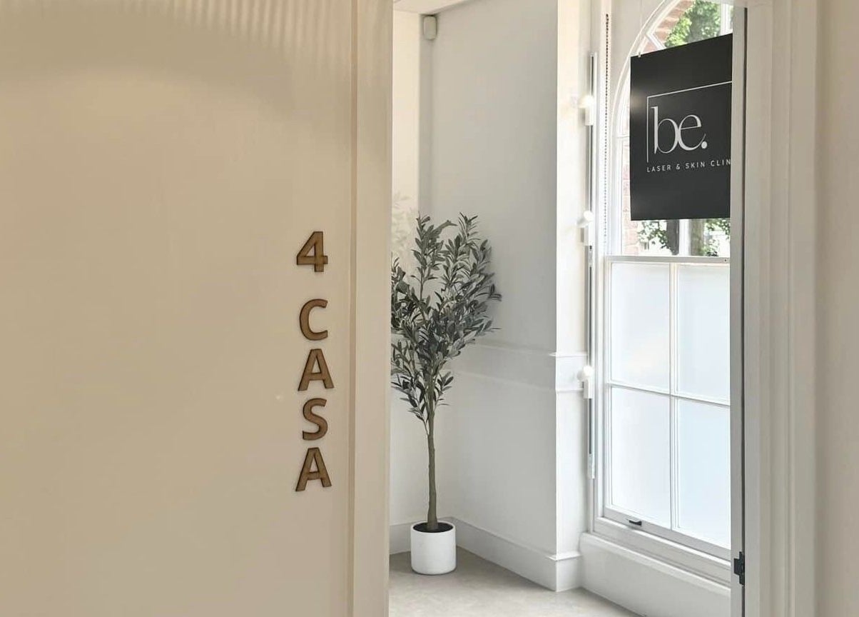 Entrance to Be. Laser and Skin Clinic in Taunton, England, with a welcoming plant near the window.