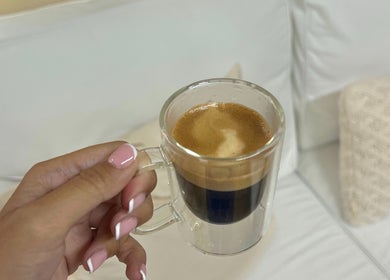 Hand with pink nails holds espresso at Palm, Montréal, Québec, CA. Relaxing atmosphere.