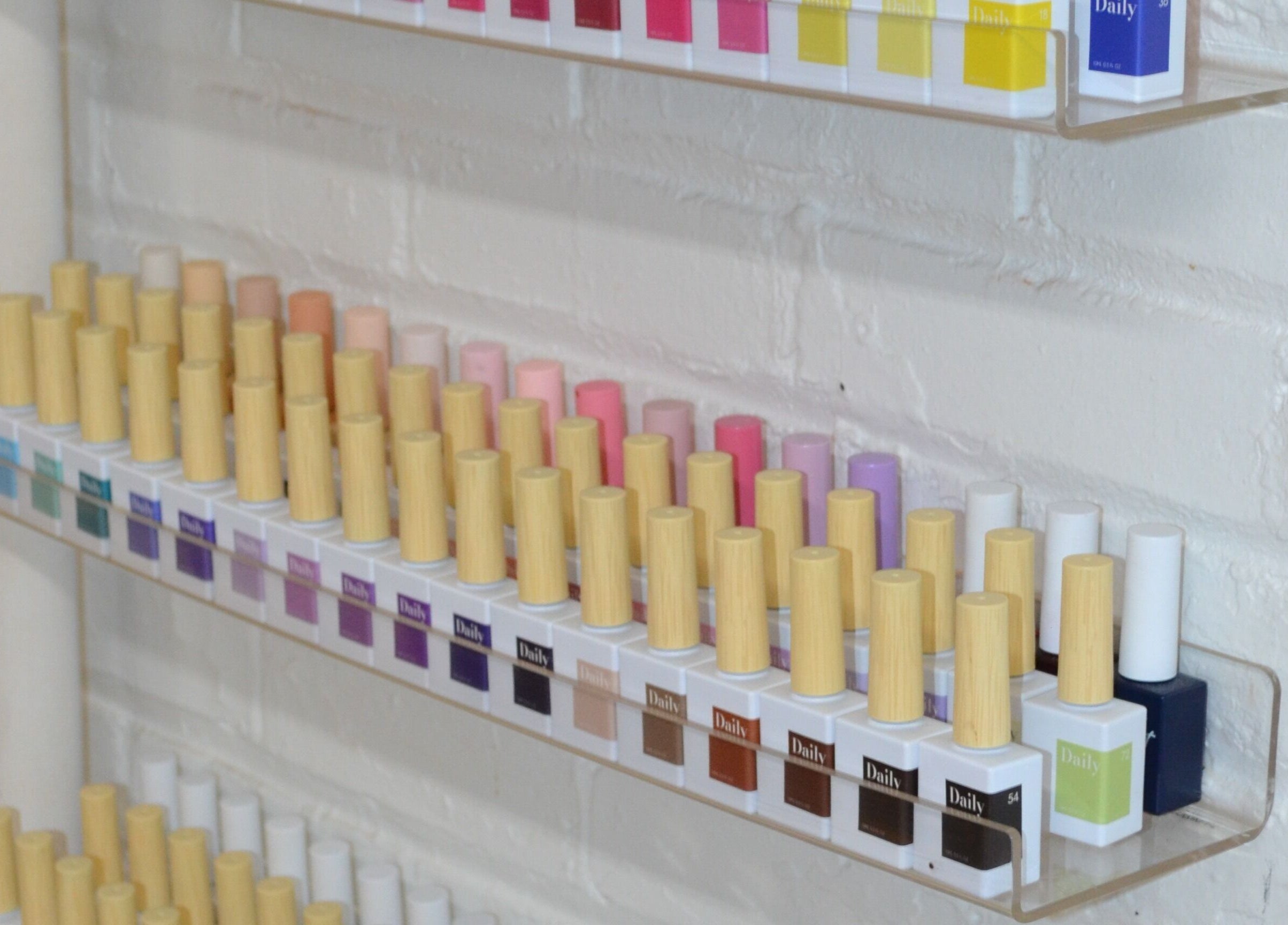 Vibrant nail polishes neatly on display at Palm in Montréal, Québec, CA, showcasing diverse shades.