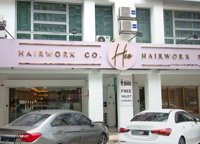 Exterior of Hairworx Co. in Kuala Lumpur, Wilayah Persekutuan Kuala Lumpur, MY with sign and parked cars.