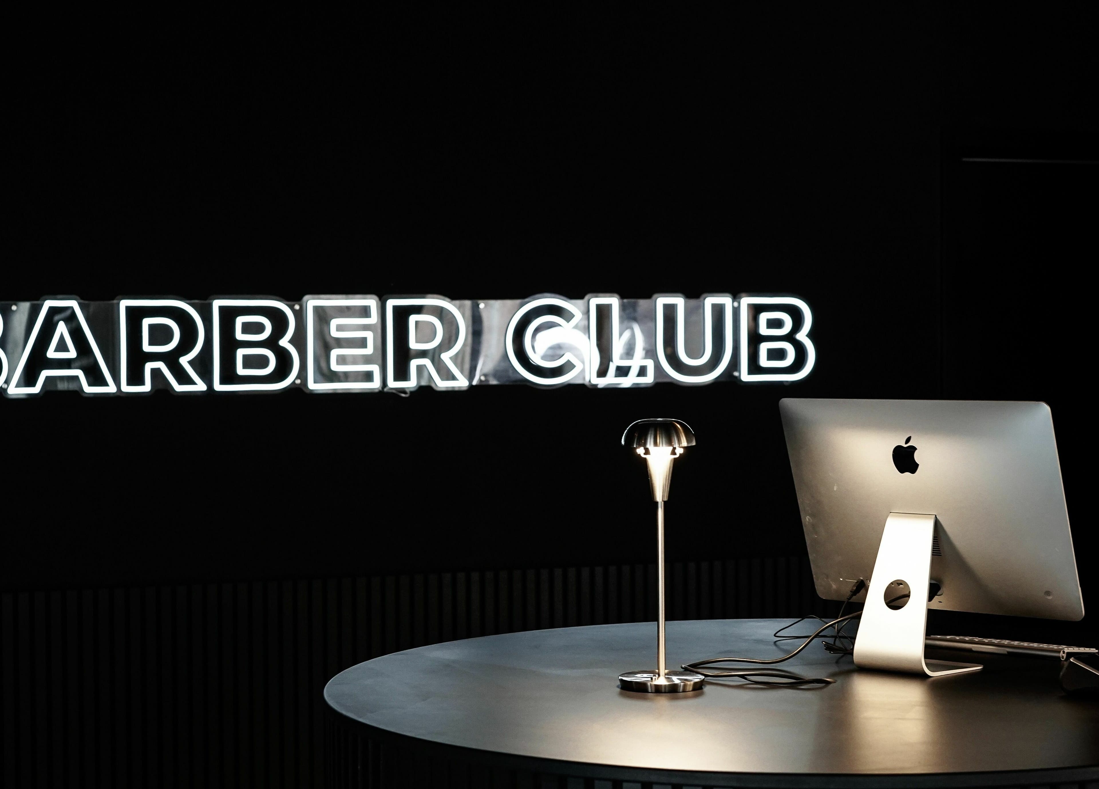 Stilfuld reception i Barber Club, Aalborg, DK. Neon skilt og moderne indretning skaber en varm velkomst.