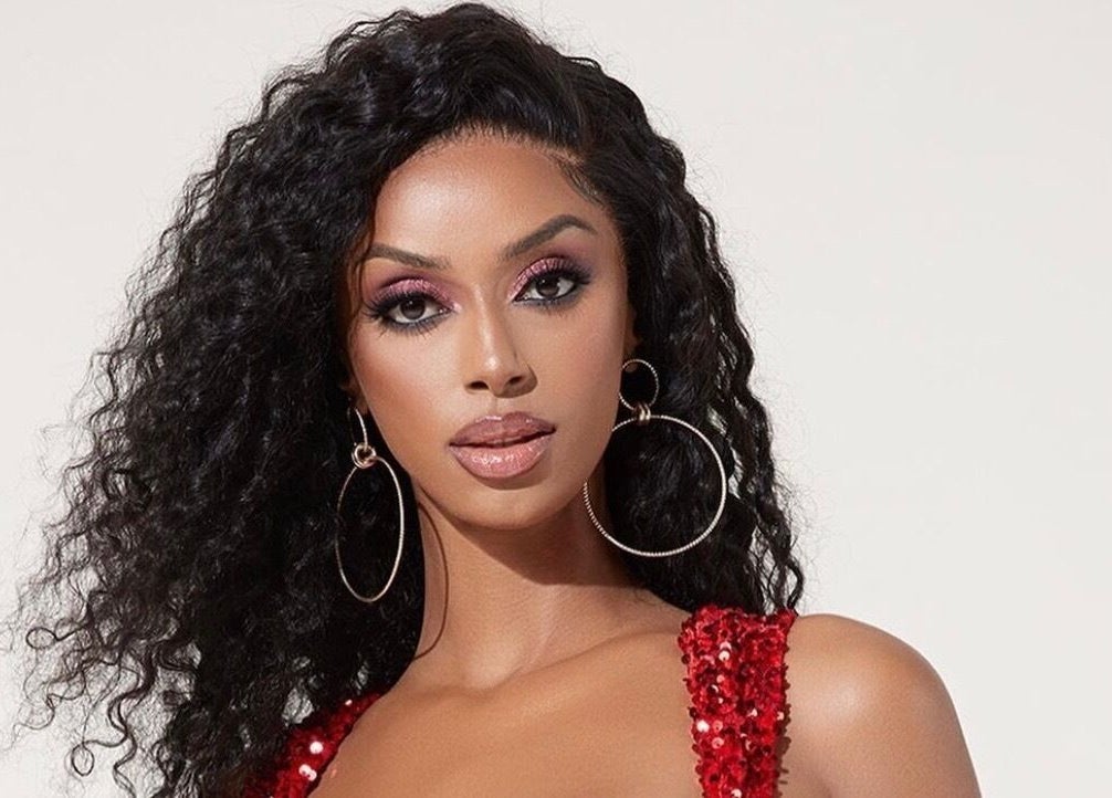 A glamorous model in a red dress at DXA Beauty, Enfield, England, GB showcasing elegant fashion and style.