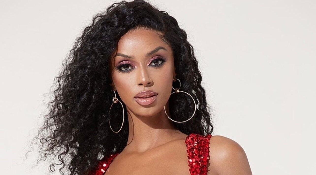 A glamorous model in a red dress at DXA Beauty, Enfield, England, GB showcasing elegant fashion and style.