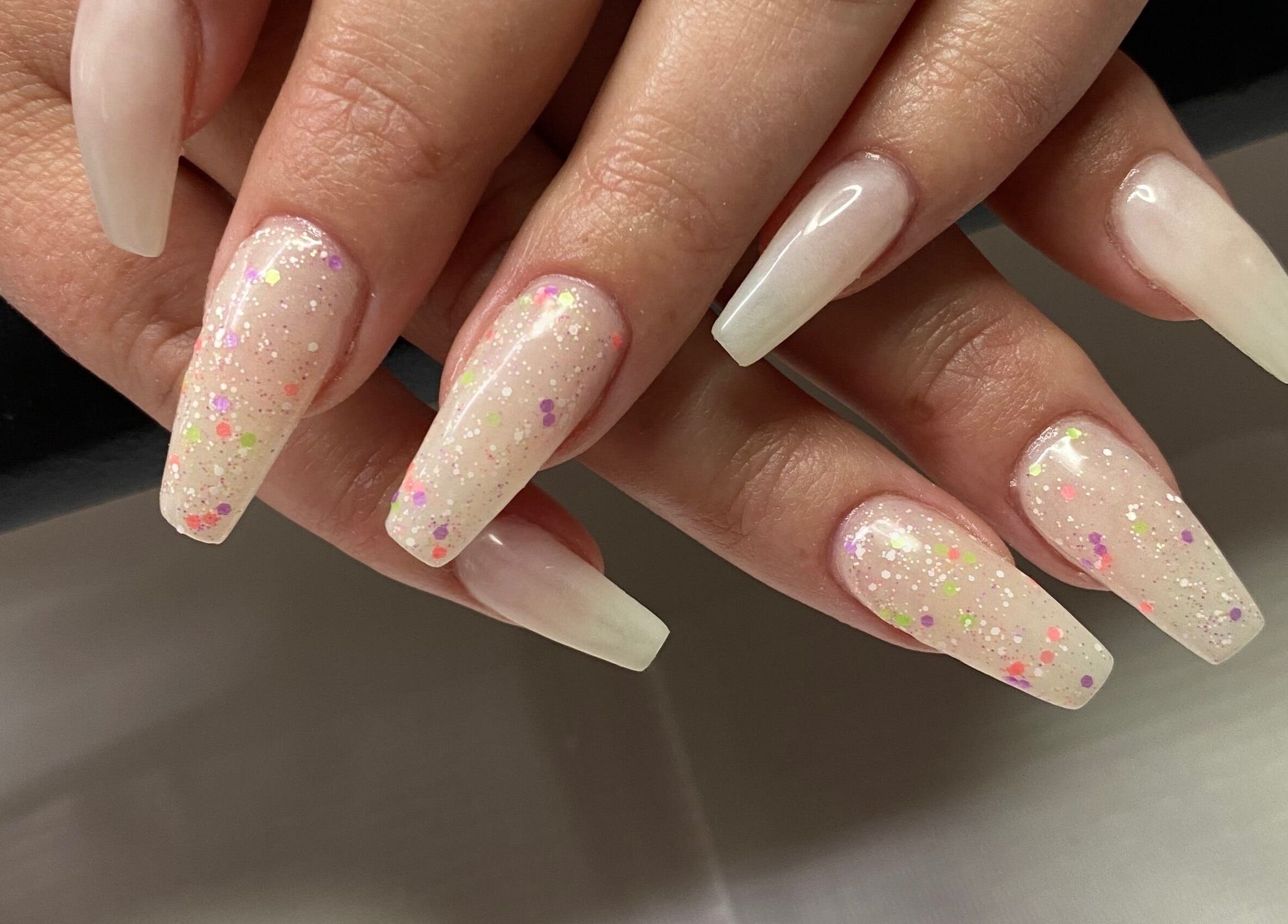 Elegant nail art with glittering tips at Infinite, Benoni, Gauteng, ZA, showcasing expert manicure services.