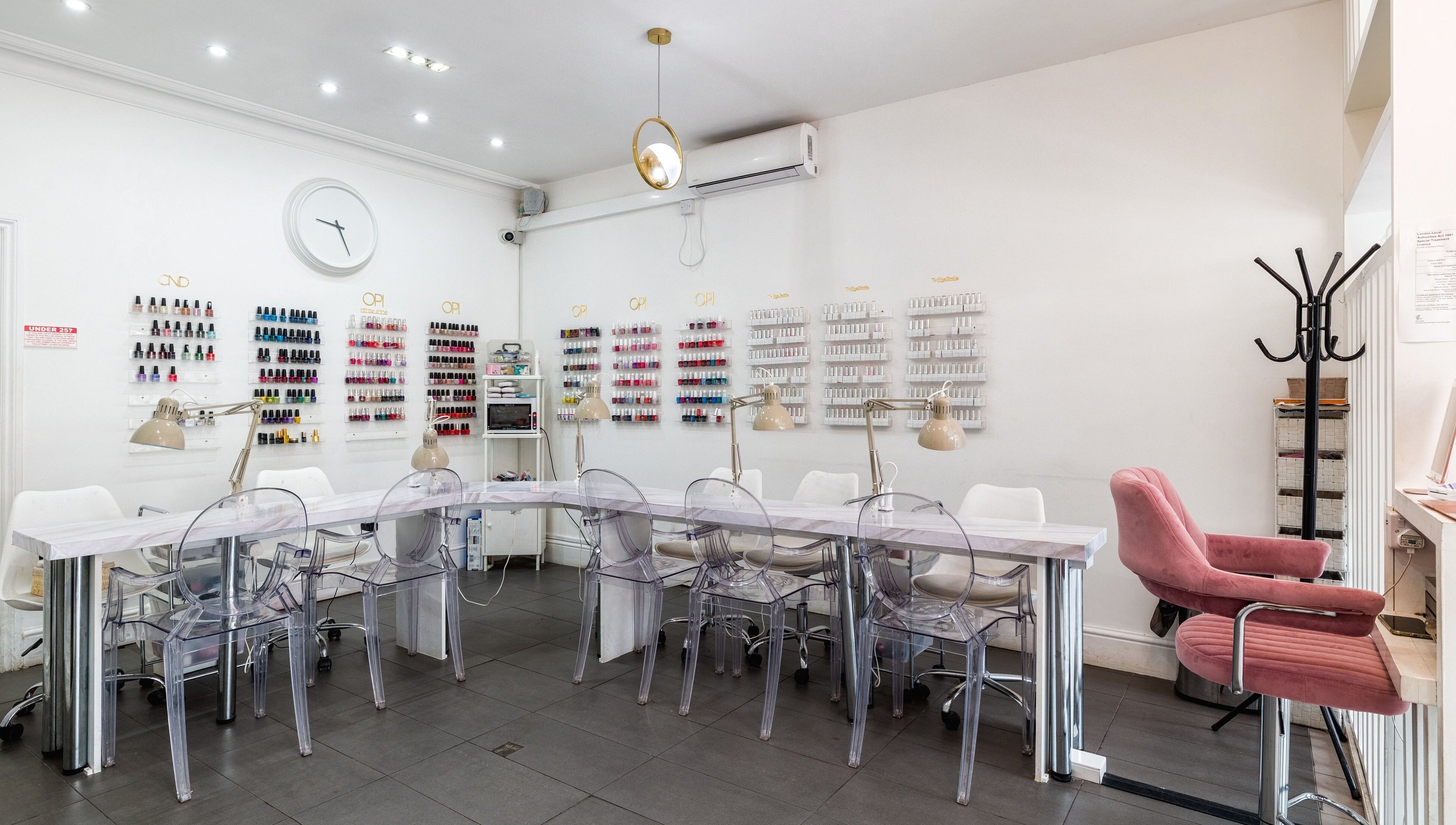 Modern interior of Blush Nail Bar in London, England, GB, showcasing nail polish displays and seating.