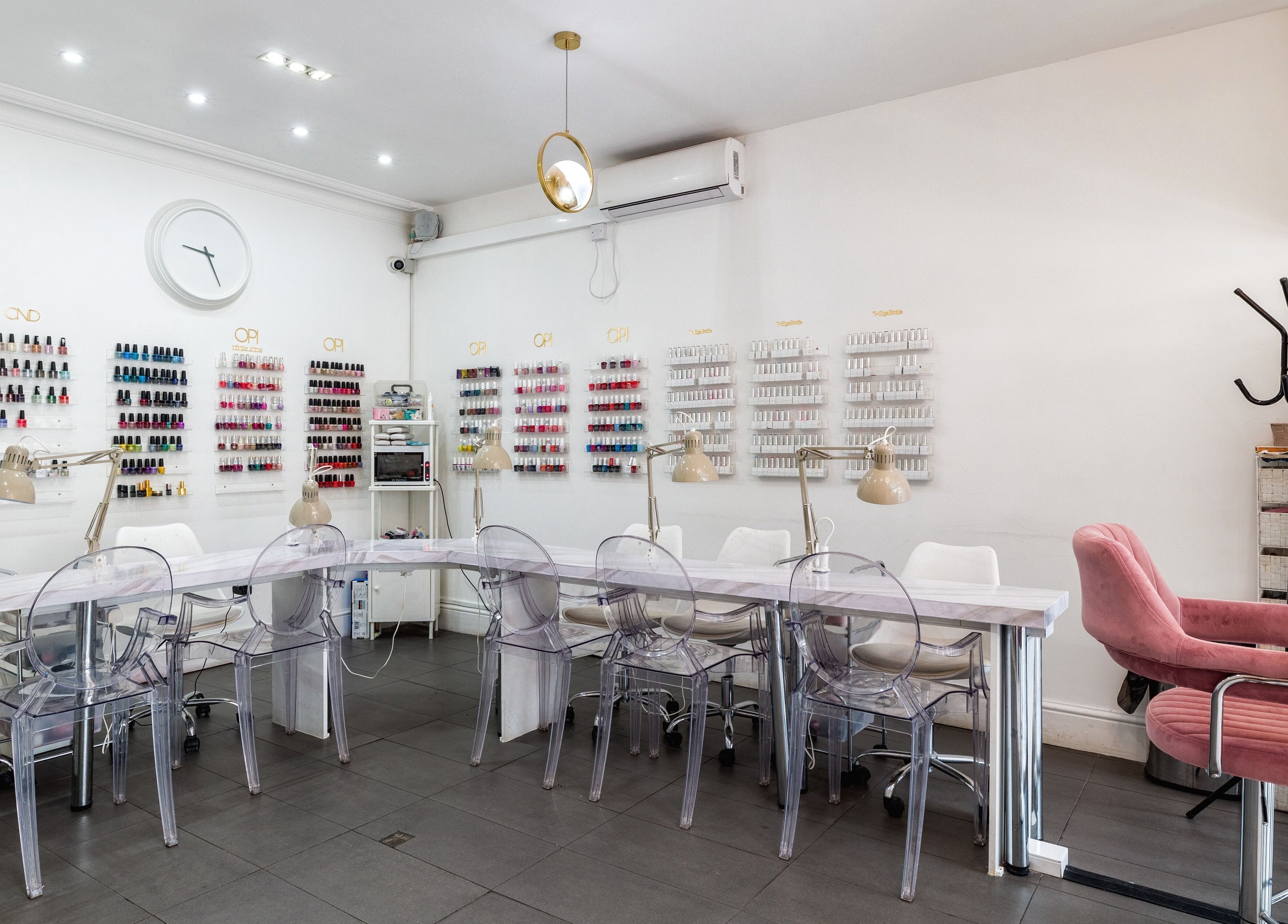Modern interior of Blush Nail Bar in London, England, GB, showcasing nail polish displays and seating.