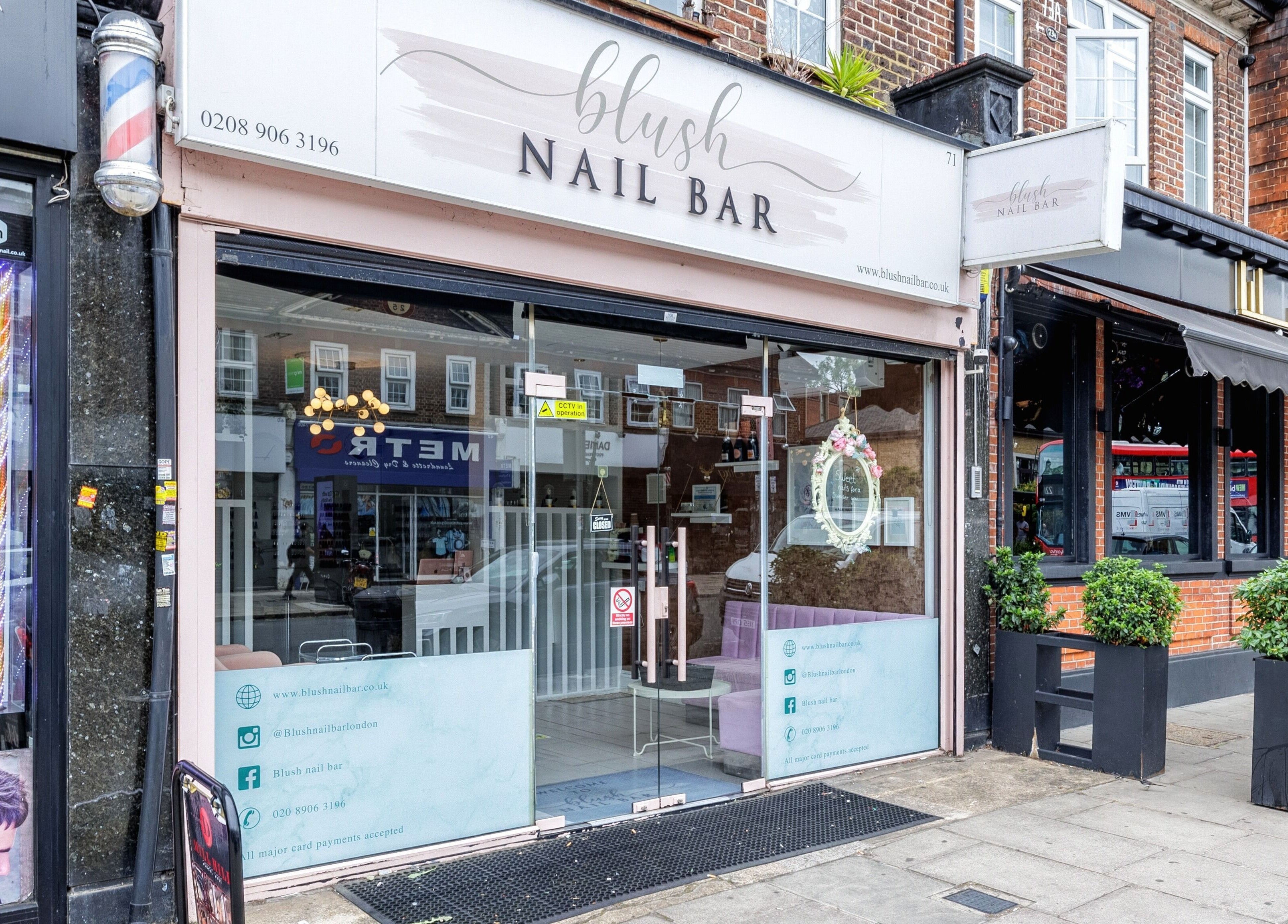 Exterior of Blush Nail Bar, London, England, GB, showcasing modern glass façade and stylish signage.