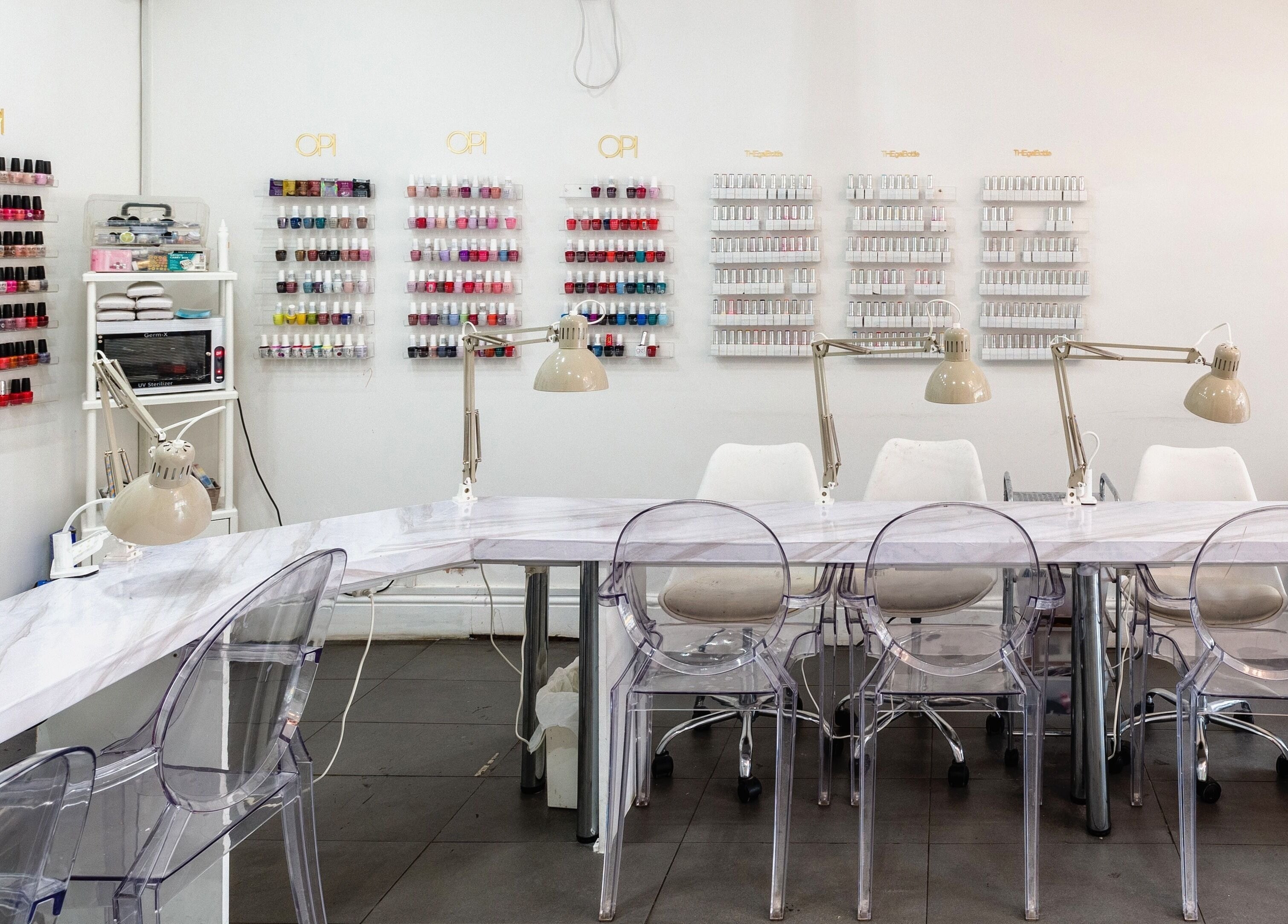 Bright, modern nail salon at Blush Nail Bar, London, England, GB with stylish tables and colorful polish displays.