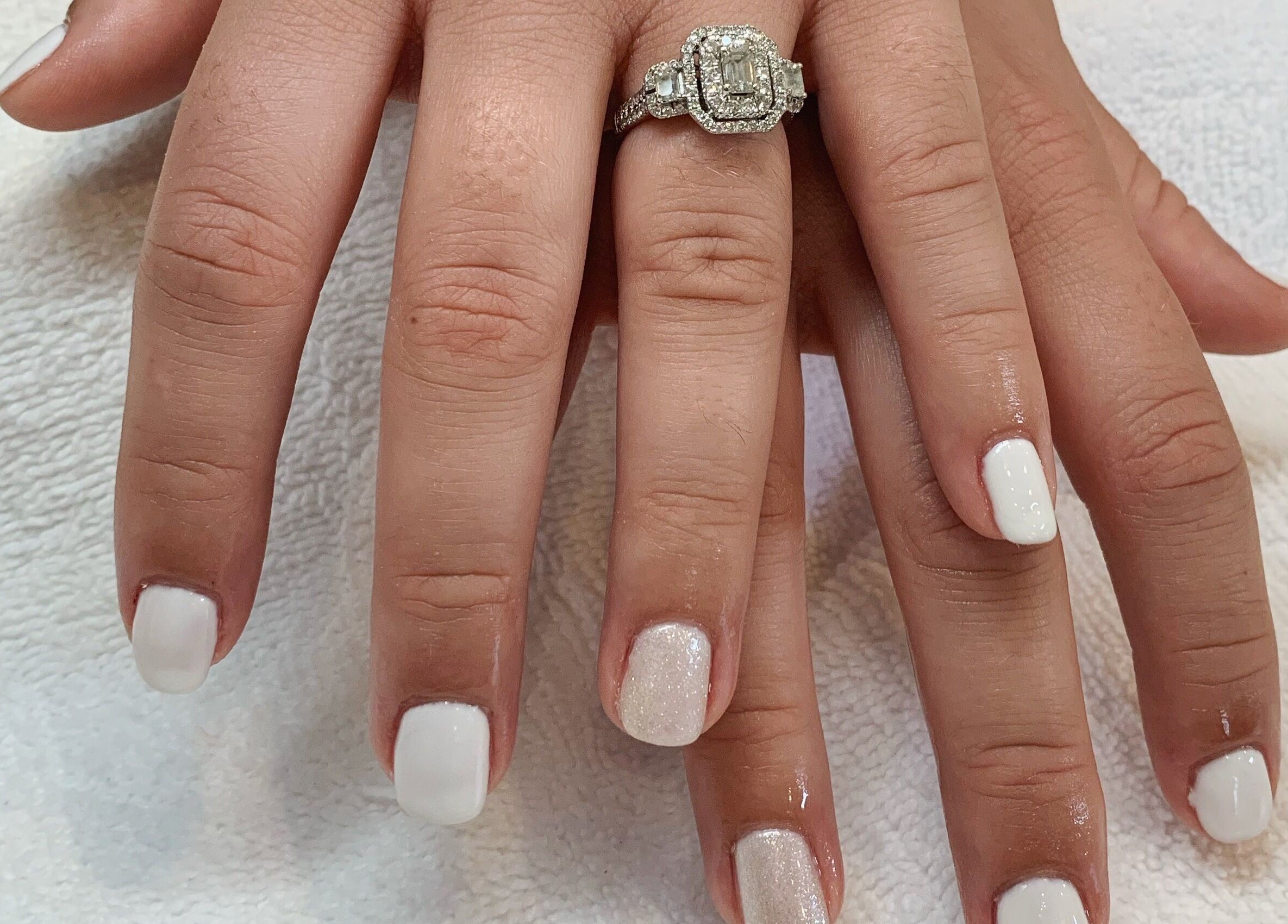 Elegant white manicure with ring at Sidney Aesthetics, Owen Sound, Ontario, CA.
