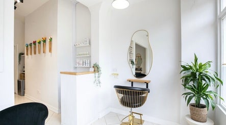 Stylish salon corner in Megan Gribbon Hair, Torquay, England, GB with modern chair and plants.