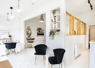Spacious, chic interior of Megan Gribbon Hair salon in Torquay, England, GB with modern decor and seating.