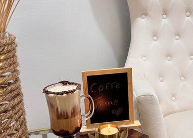 Relax at Brazilian Beauty Spa, Peabody, Massachusetts with a cozy coffee setup by a plush chair.