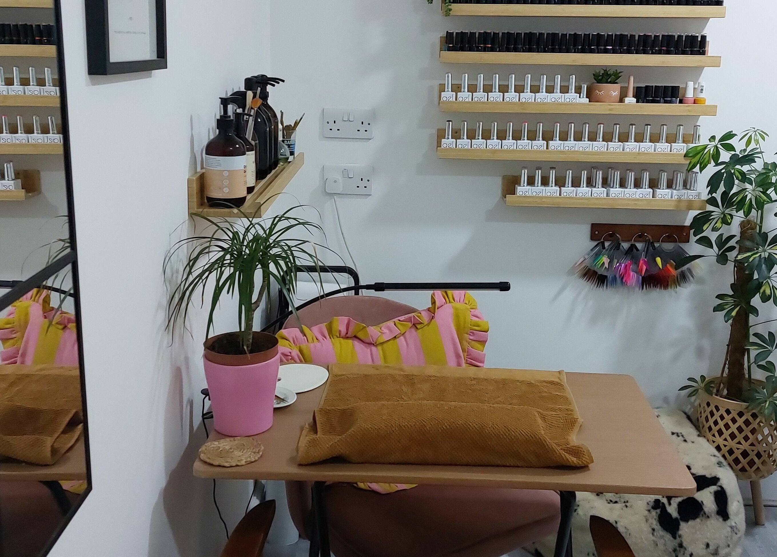 Chic nail area at T'Studio, Basingstoke, England, GB featuring organized polish display and potted plants.