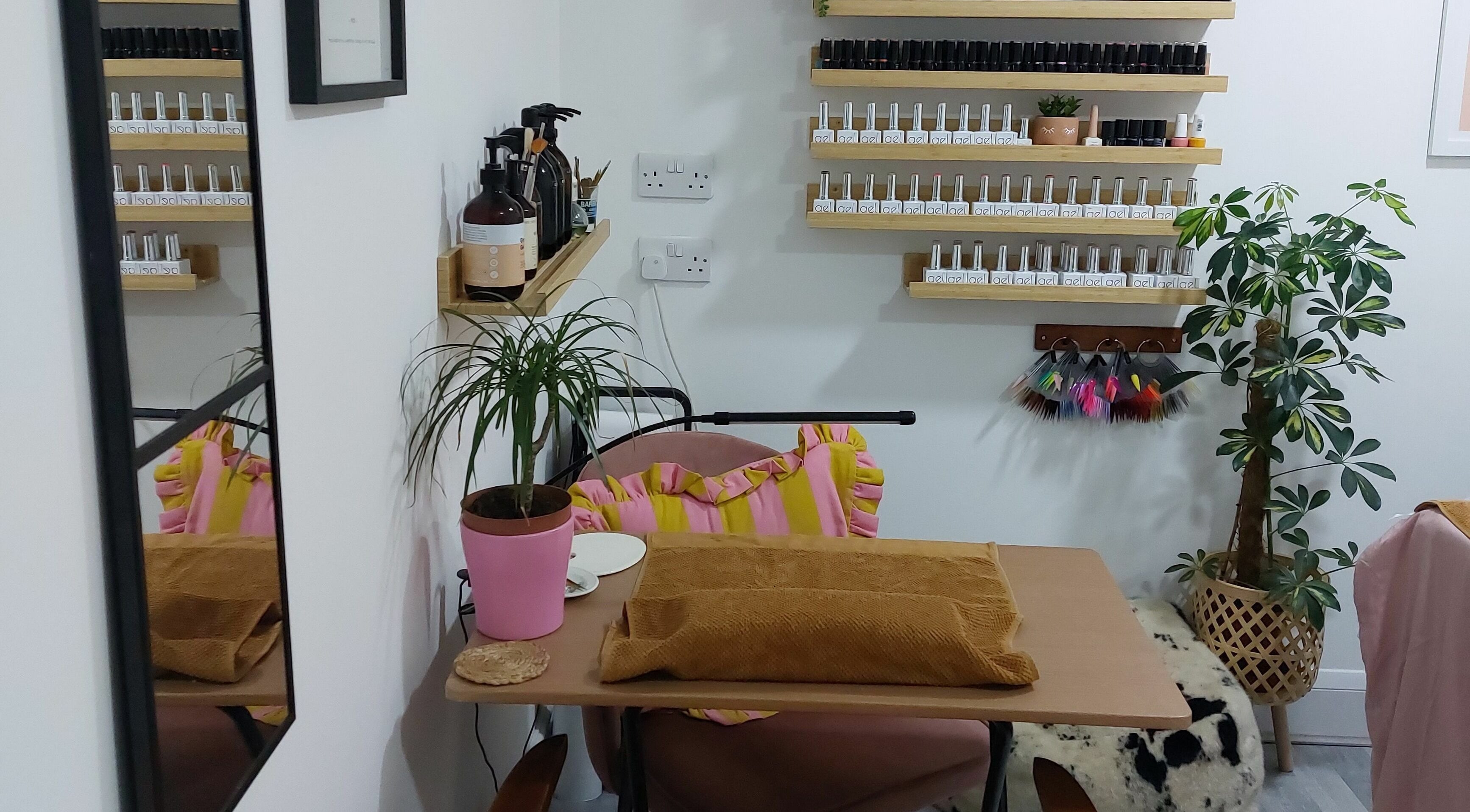 Chic nail area at T'Studio, Basingstoke, England, GB featuring organized polish display and potted plants.