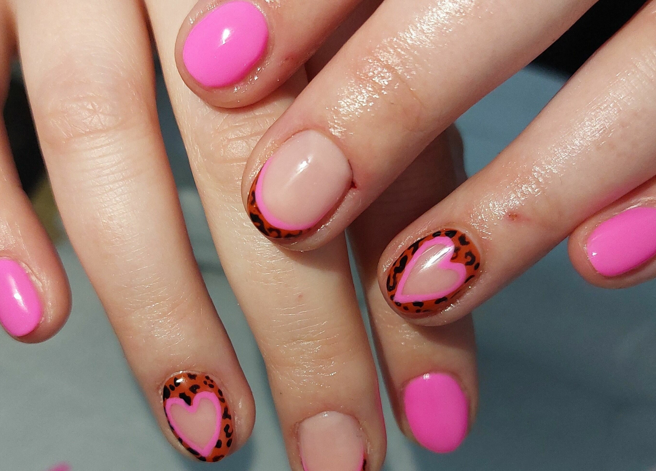 Vibrant pink nails with heart designs at T'Studio, Basingstoke, England, GB.