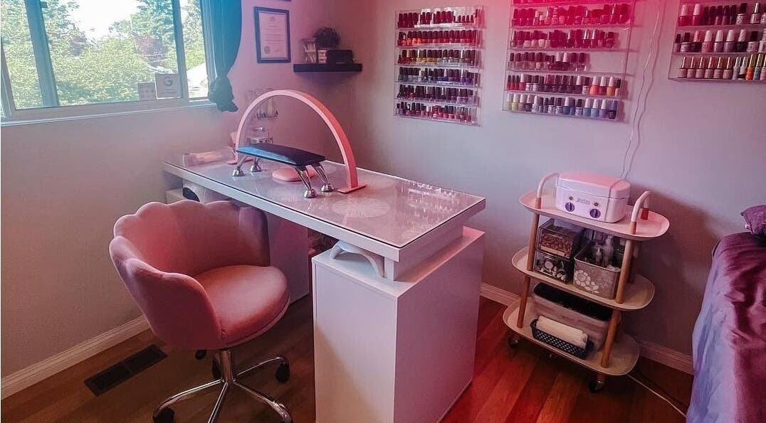 Chic nail salon setup at Esthetics by Lyss, Nanaimo, BC, CA; featuring elegant pink chair and polish display.