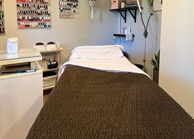 Relaxing treatment room at Esthetics by Lyss, Nanaimo, British Columbia, CA, featuring cozy bed and nail polish collection.