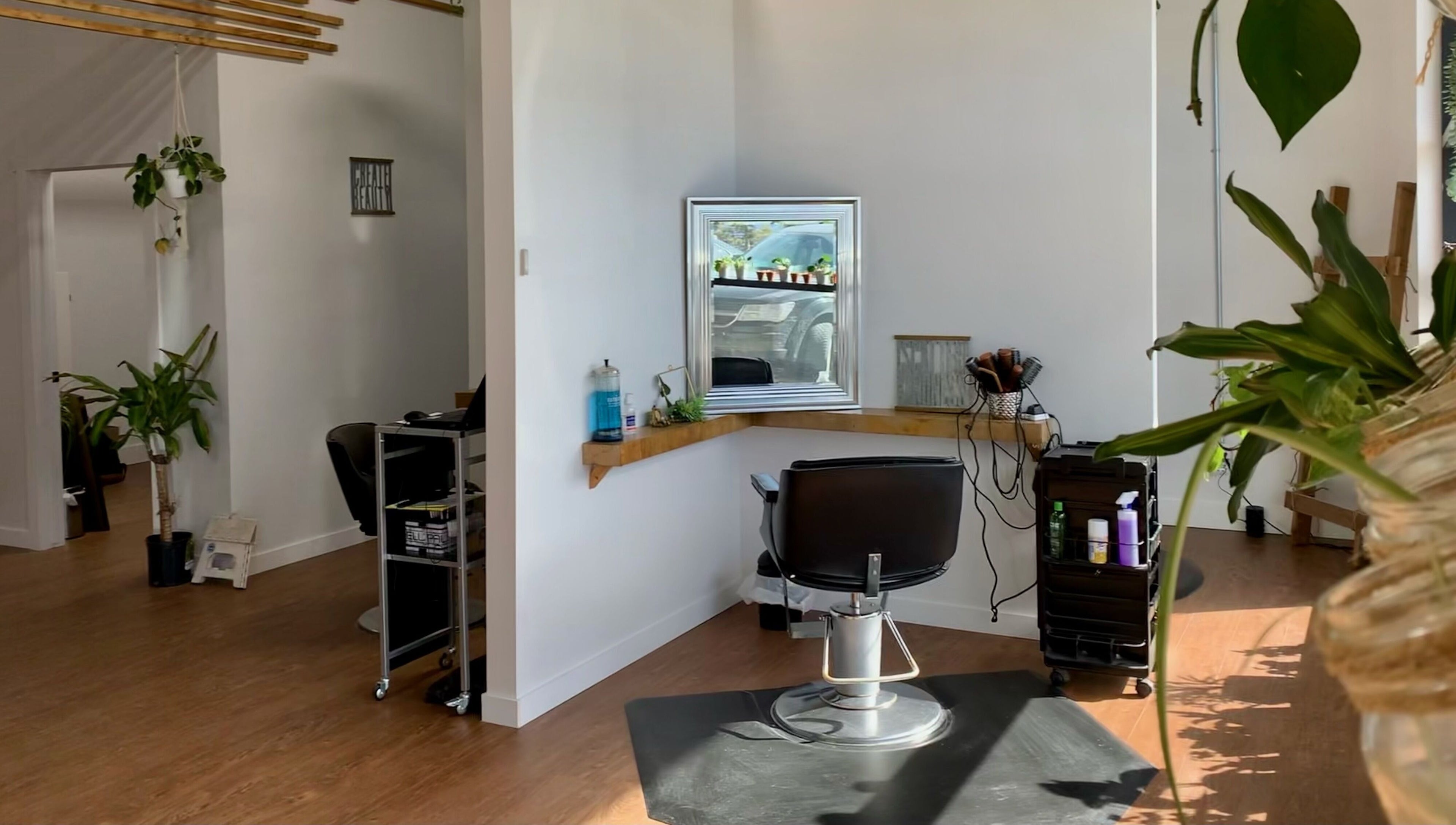 Cozy interior of Turning Heads Hair Studio, Calgary, Alberta, CA, with salon chair, plants, and bright lighting.