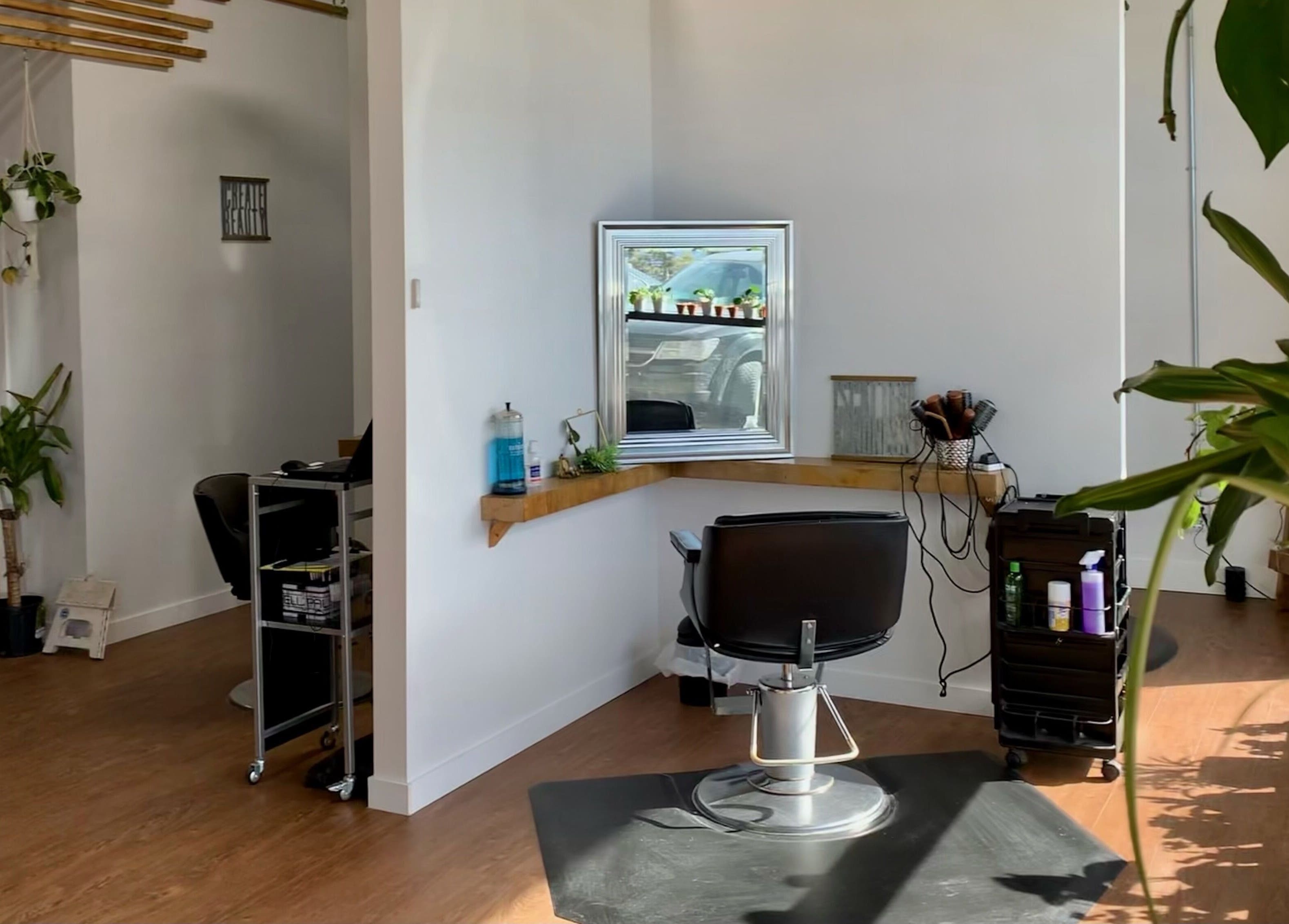 Cozy interior of Turning Heads Hair Studio, Calgary, Alberta, CA, with salon chair, plants, and bright lighting.