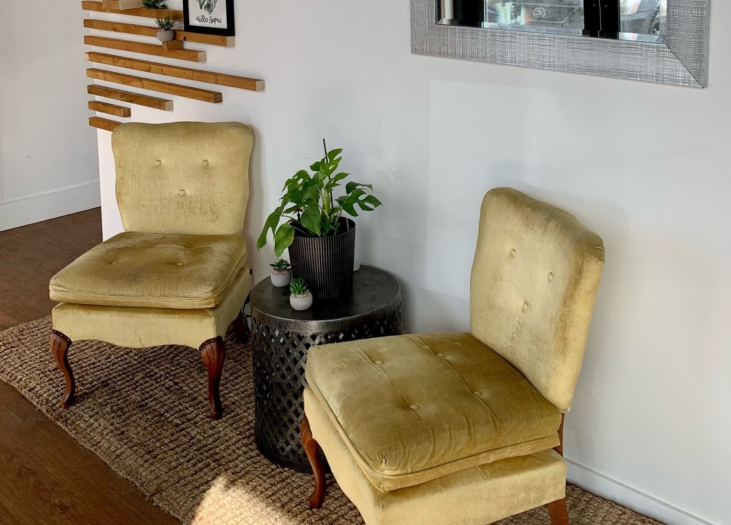 Elegant seating area at Turning Heads Hair Studio, Calgary, Alberta, CA with vintage chairs and plants.