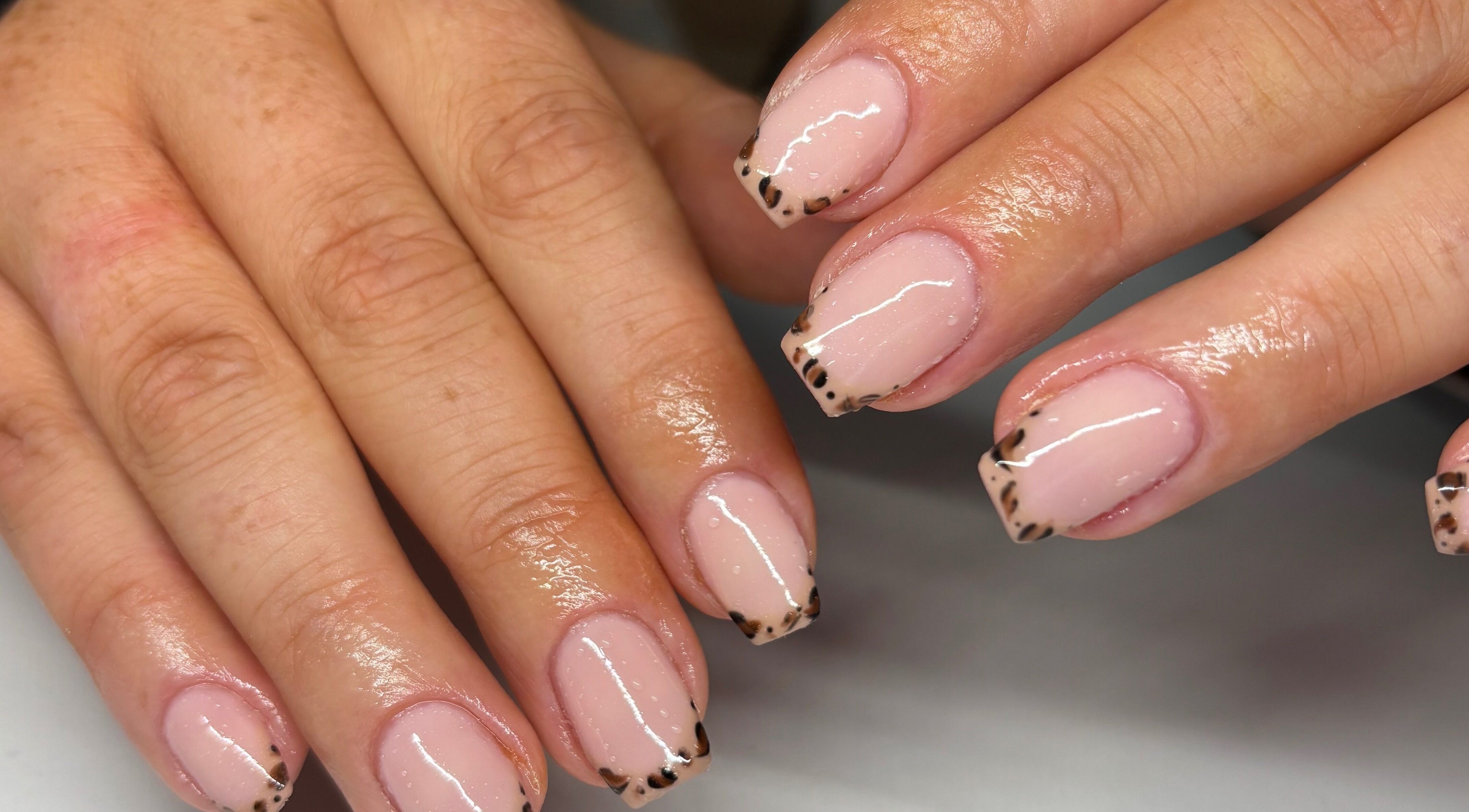 Elegantly painted leopard French tips at Nails by Em, Gloucester, England, GB.