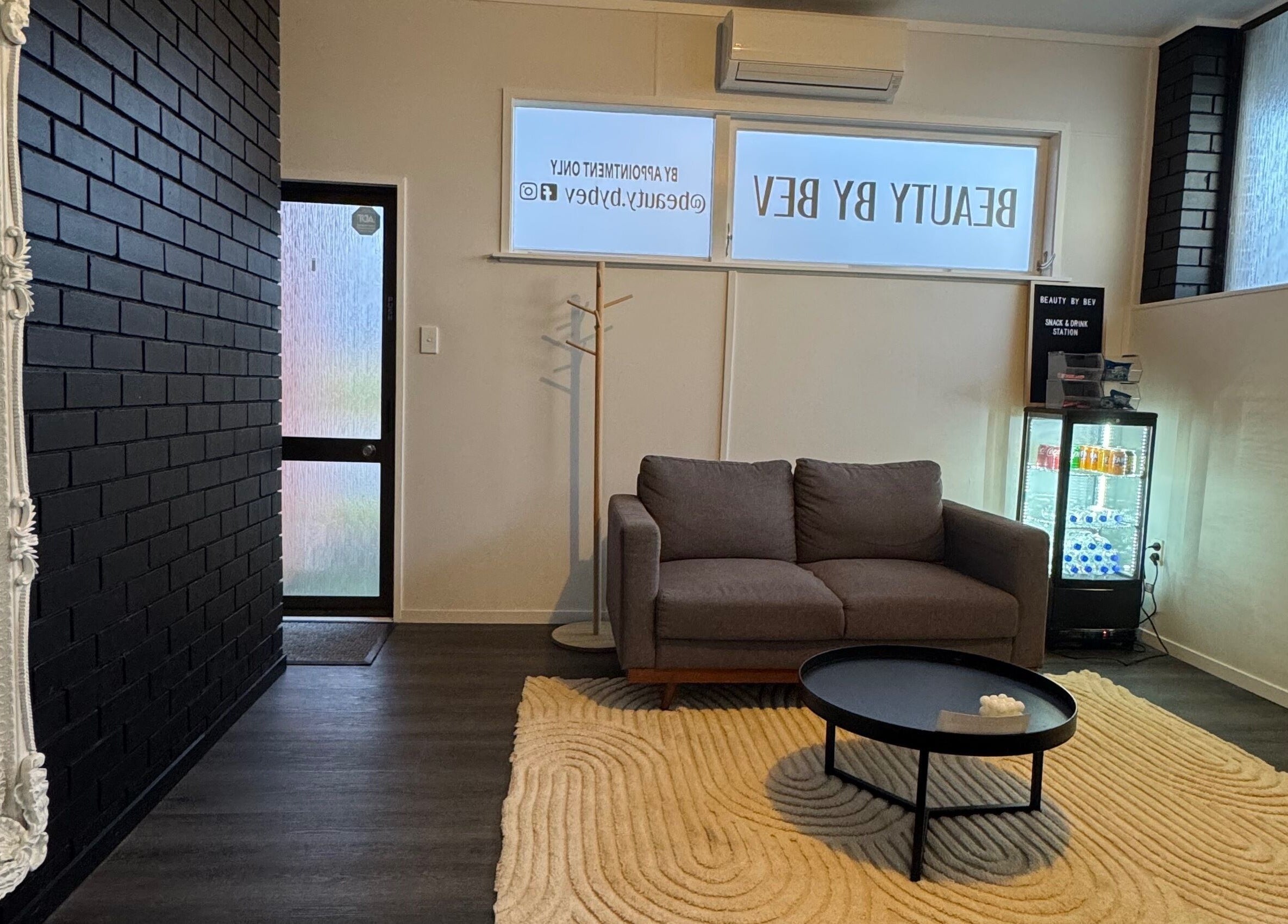 Stylish waiting area at Beauty By Bev in Levin, Manawatu-Wanganui, NZ, featuring a cozy sofa and modern decor.