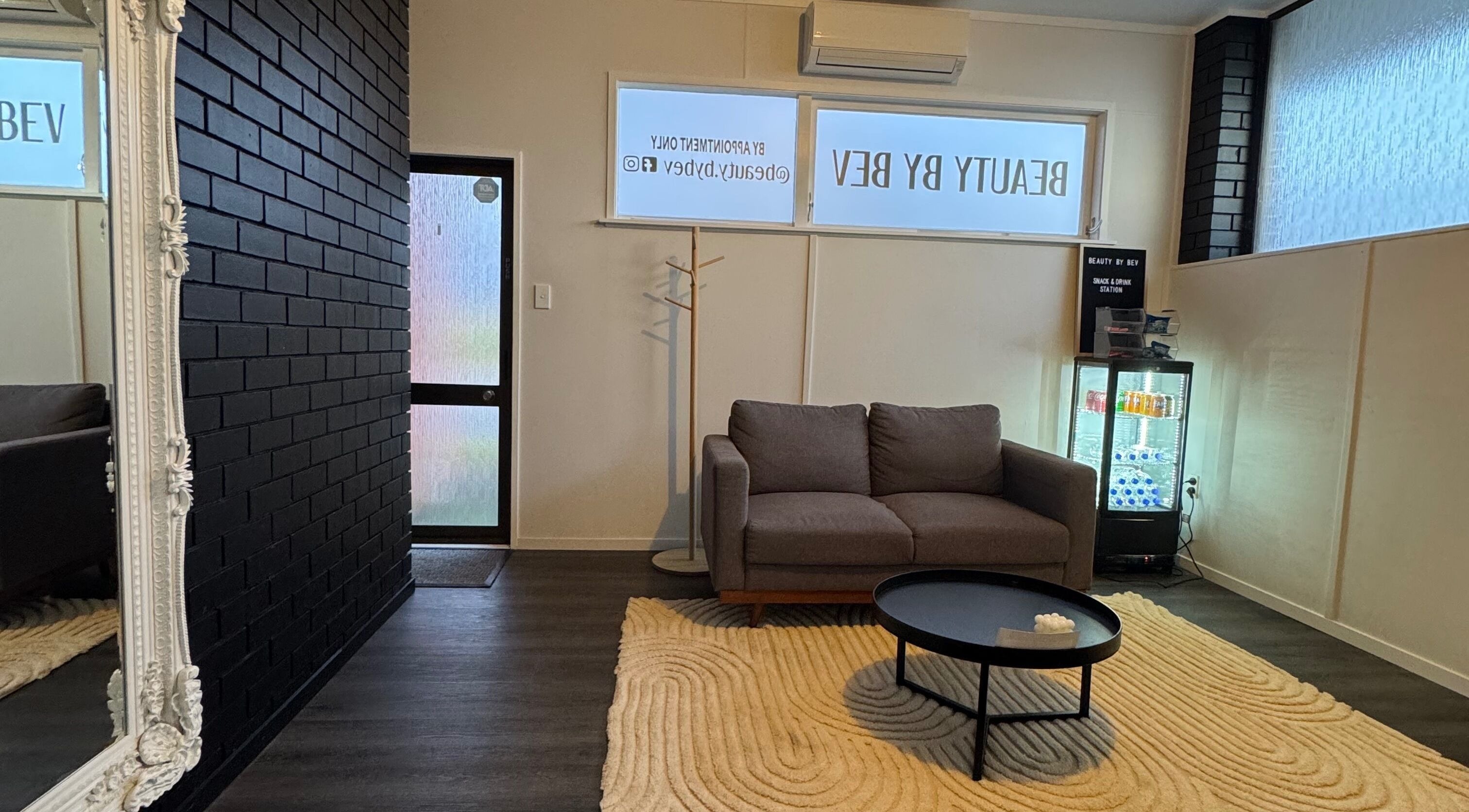 Stylish waiting area at Beauty By Bev in Levin, Manawatu-Wanganui, NZ, featuring a cozy sofa and modern decor.