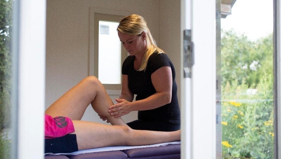 Massage therapist at CJ Soft Tissue & Massage Therapy in Wellington, England, provides leg therapy.