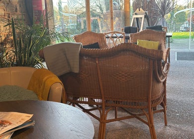 Relaxing seating area at CJ Soft Tissue & Massage Therapy, Wellington, England with wicker chairs and soft lighting.