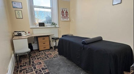 Massage therapy room at CJ Soft Tissue & Massage Therapy, Wellington, England with massage table and serene decor.