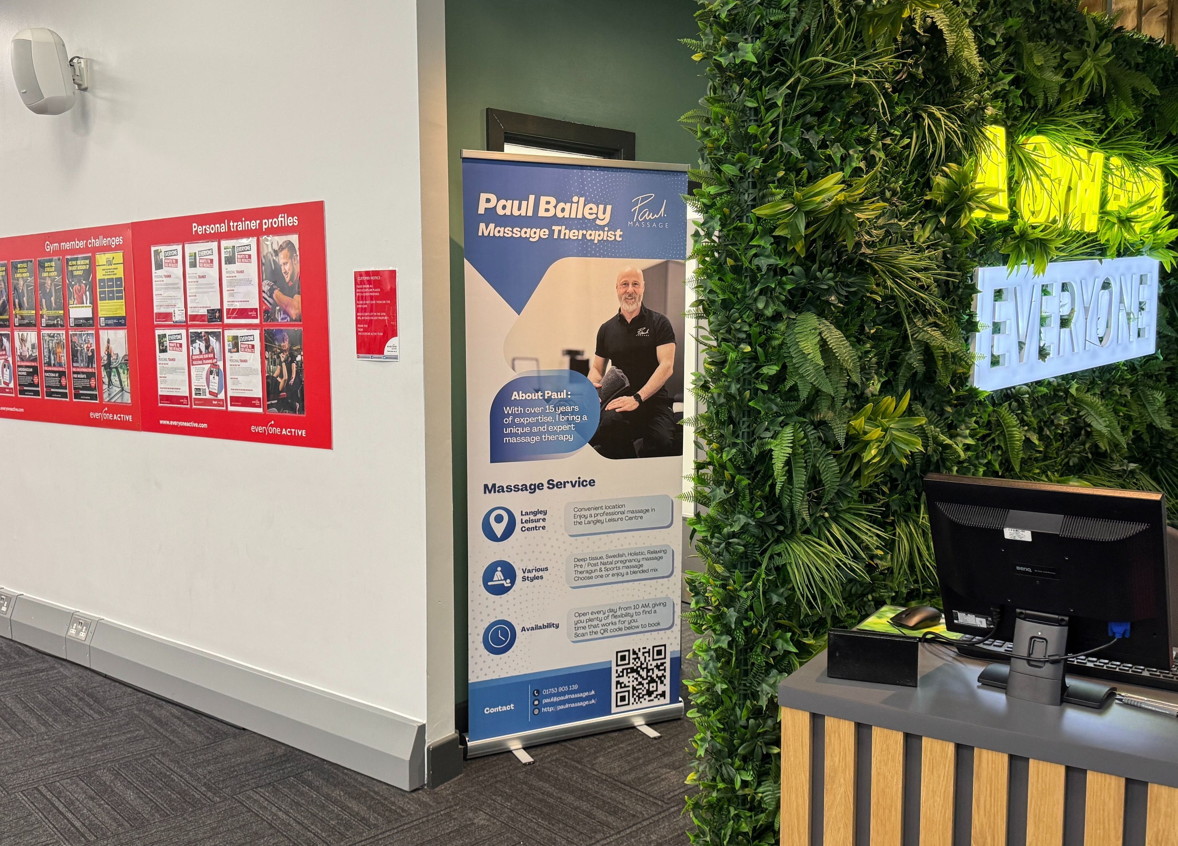 Reception at Paul Massage in Langley Leisure Centre, Slough, England, featuring lush green décor and promotional display.