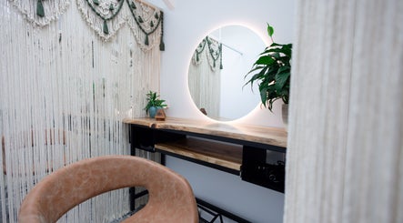 Stylish seating and round mirror at ECOHILL Hair Boutique, Boondall, Queensland, AU, showcasing elegant decor.