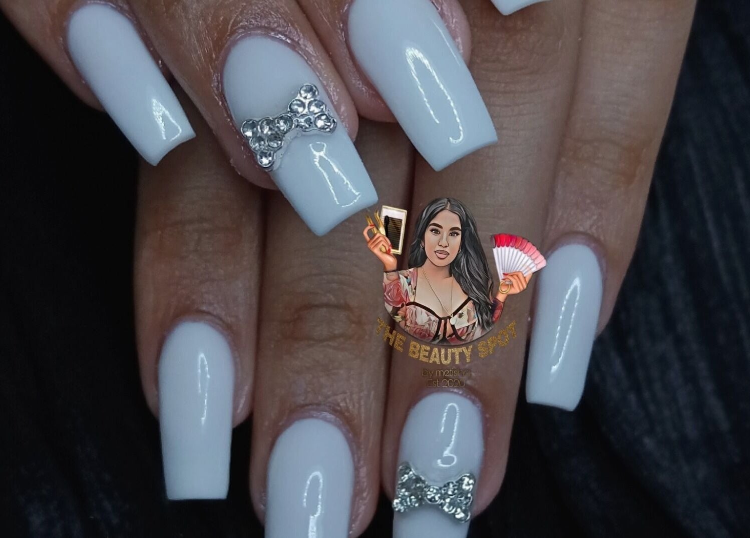 Elegant white nails with rhinestone bows at The Beauty Spot at nailsby.metisha in Queensburgh, Kwazulu-Natal, ZA.