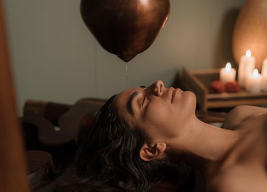 Relaxing Ayurvedic treatment at KV Wellness in Eungella, NSW, AU with warm oil gently poured on forehead.