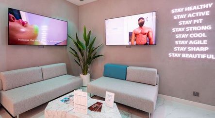 Relaxing seating area at °CRYO Dubai Hills Mall, Dubai, AE, featuring modern décor and wellness screens.