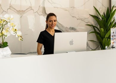 Reception desk at °CRYO Abu Dhabi Mamsha Al Saadiyat in Abu Dhabi, AE with a smiling staff member.