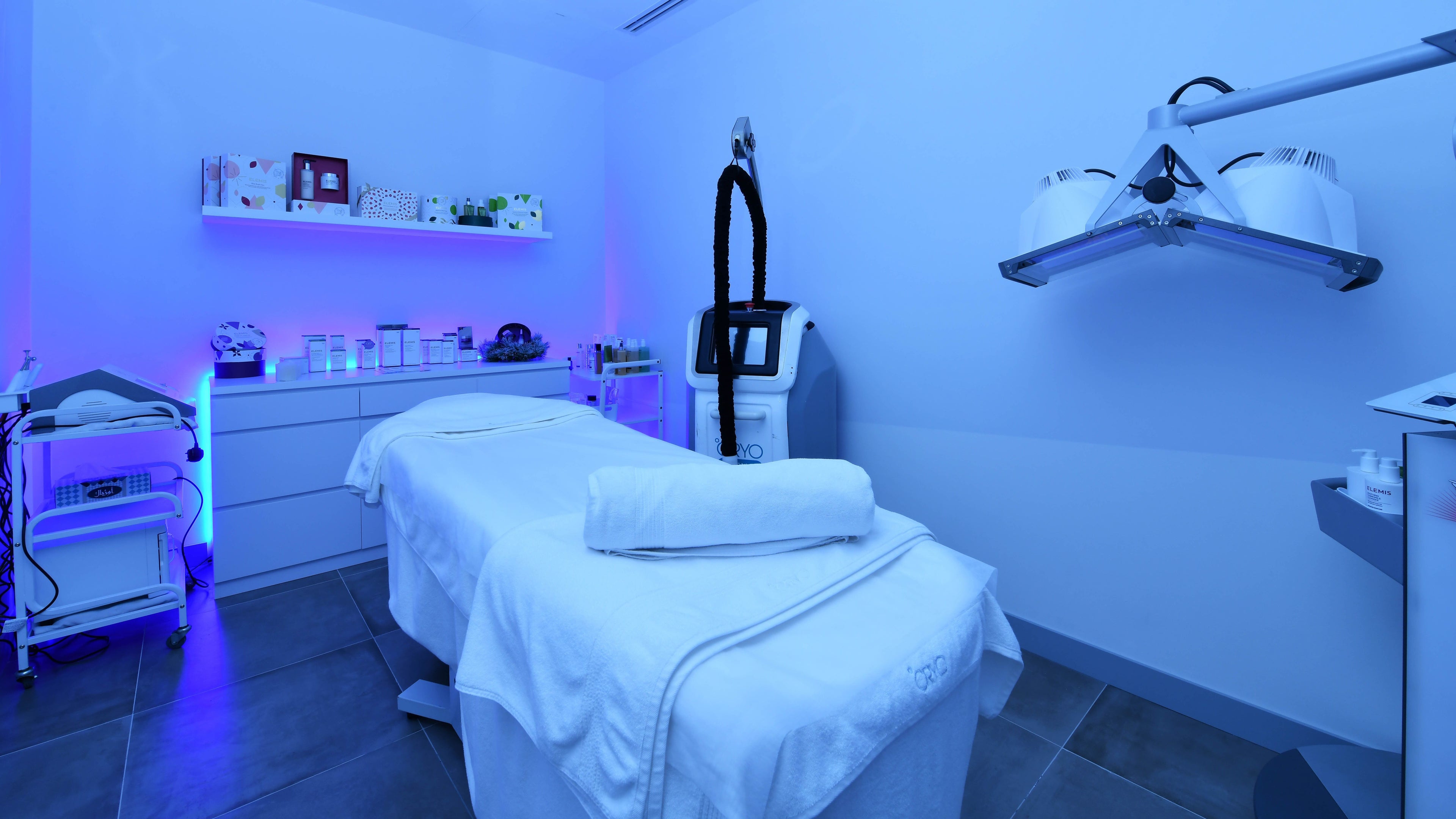 Tranquil blue-toned treatment room at °CRYO Dubai Emirates Towers, دبي, دبي, AE with a treatment bed and equipment.