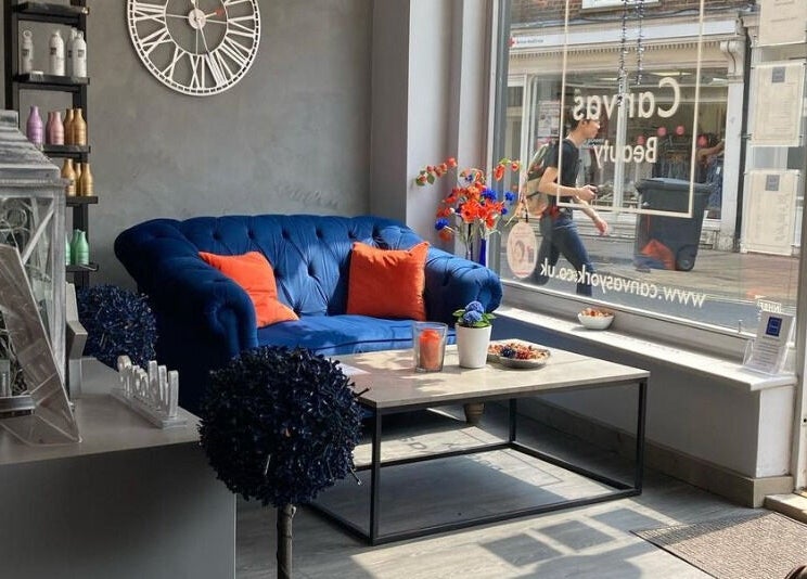 Chic waiting area at Canvas, York, England, GB showcasing a plush blue sofa and stylish decor.
