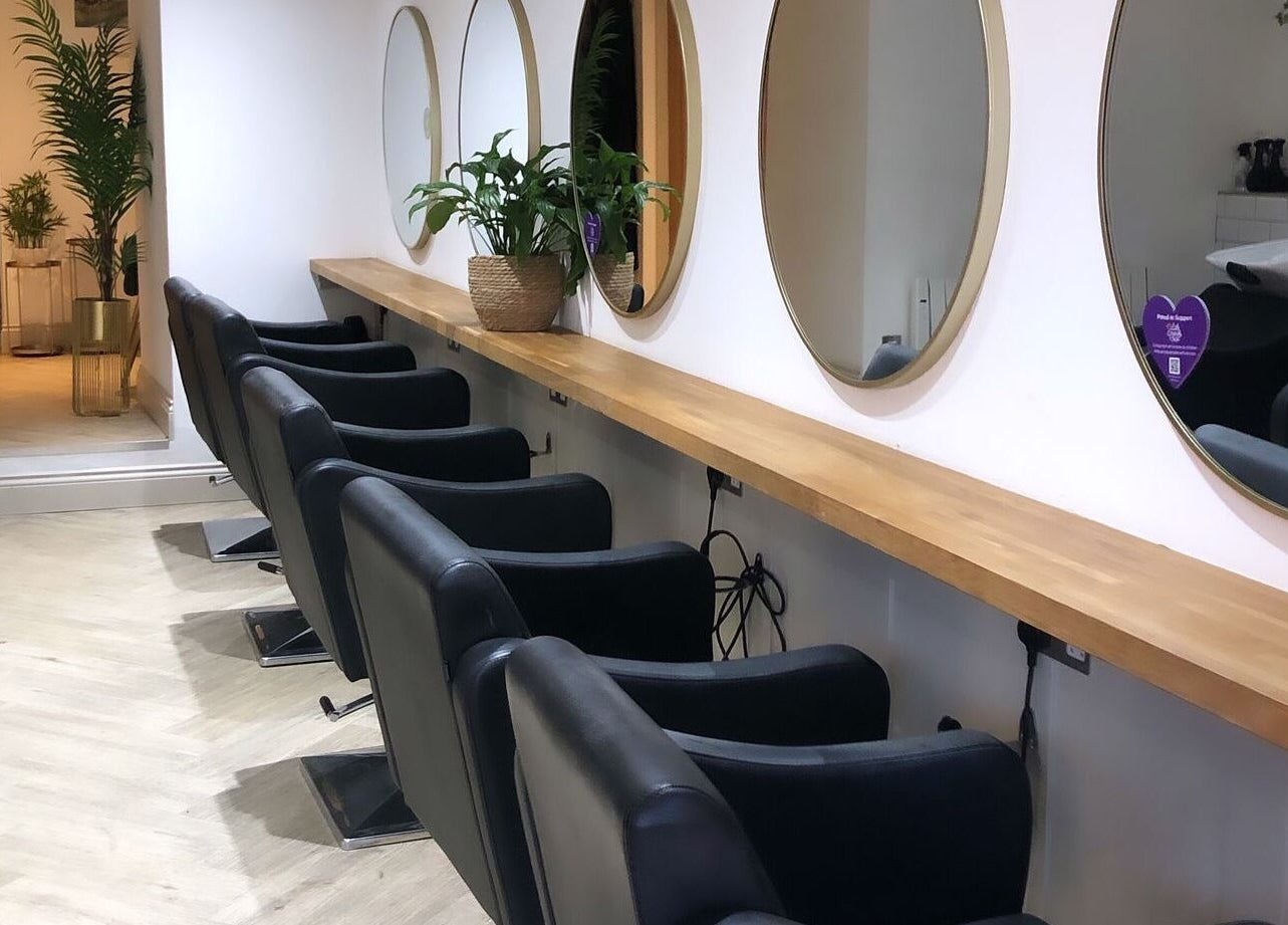 Elegant hairstyling setup at Salon Cabello, Otley, England, GB with mirrors and chairs.
