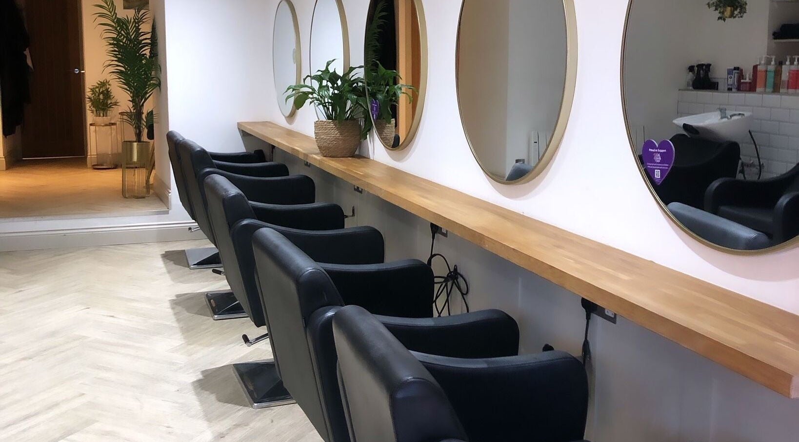 Elegant hairstyling setup at Salon Cabello, Otley, England, GB with mirrors and chairs.