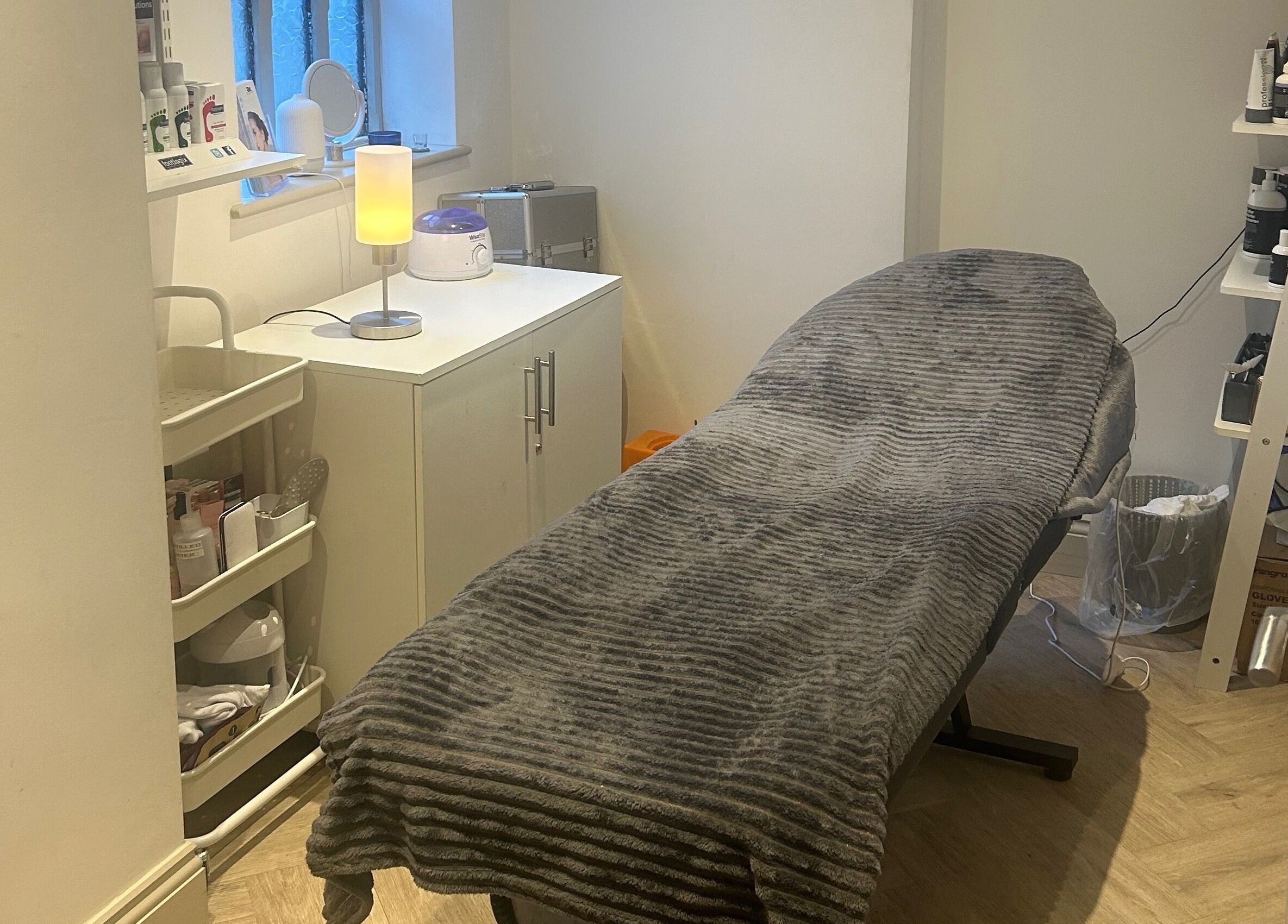 Cozy treatment room at Salon Cabello in Otley, England, GB, featuring a comfortable massage bed and soft lighting.