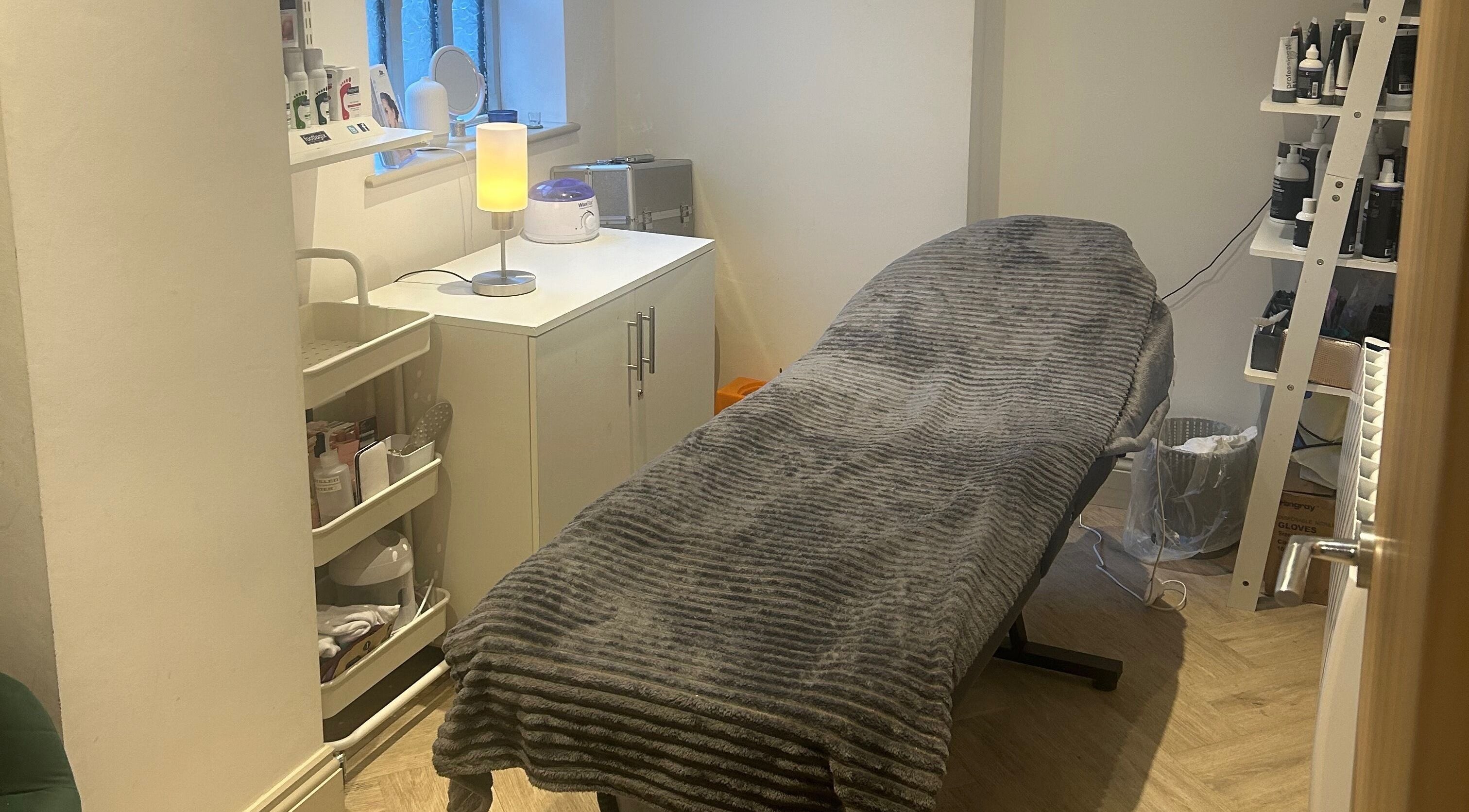 Cozy treatment room at Salon Cabello in Otley, England, GB, featuring a comfortable massage bed and soft lighting.