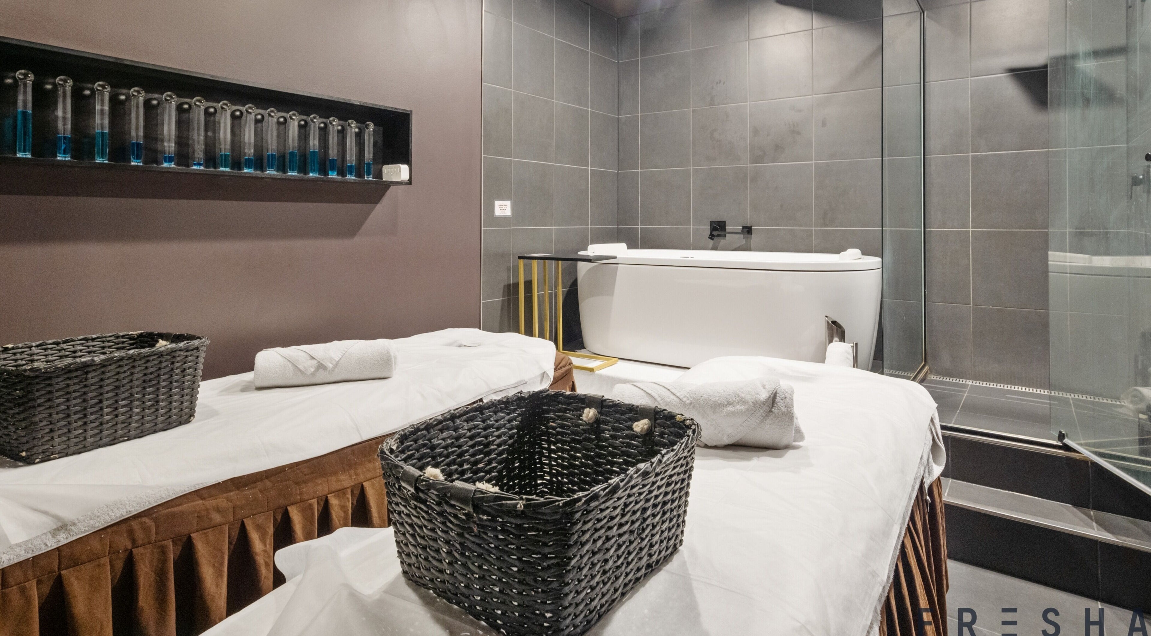 Luxurious spa room at The Savoy Hotel - V Hotel Spa, Melbourne, VIC, AU featuring a modern bathtub and massage tables.